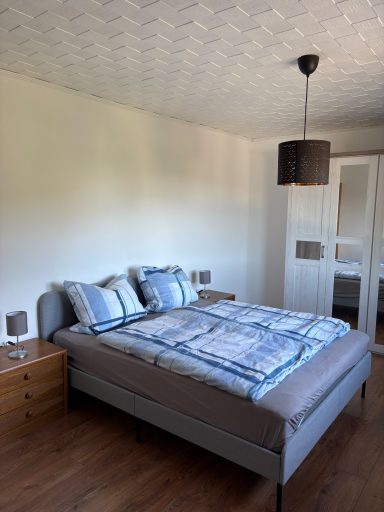 Geräumiges Schlafzimmer mit Doppelbett, Nachttischen und einem Kleiderschrank im Hintergrund.